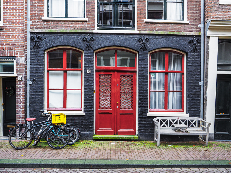 Amsterdam kamienice domy cegła rowery czerwone drzwi