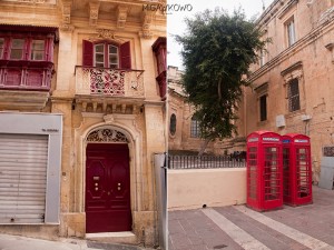 Drzwi i kolorowe brytyjskie angielskie budki telefoniczne w mieście Valletta na Malcie